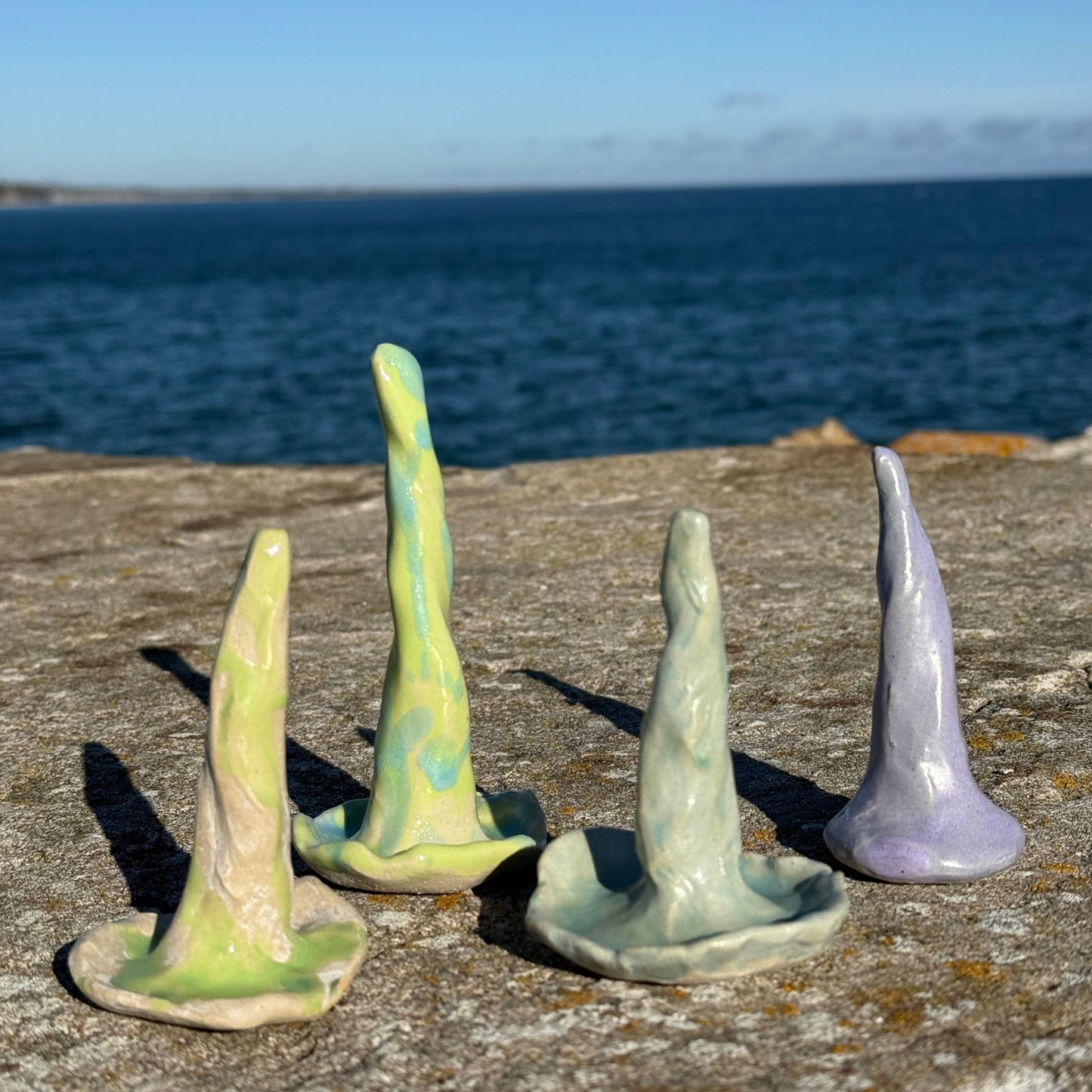 Set of ceramic ring cones in organic coral shapes on a textured surface with a blue gradient background.