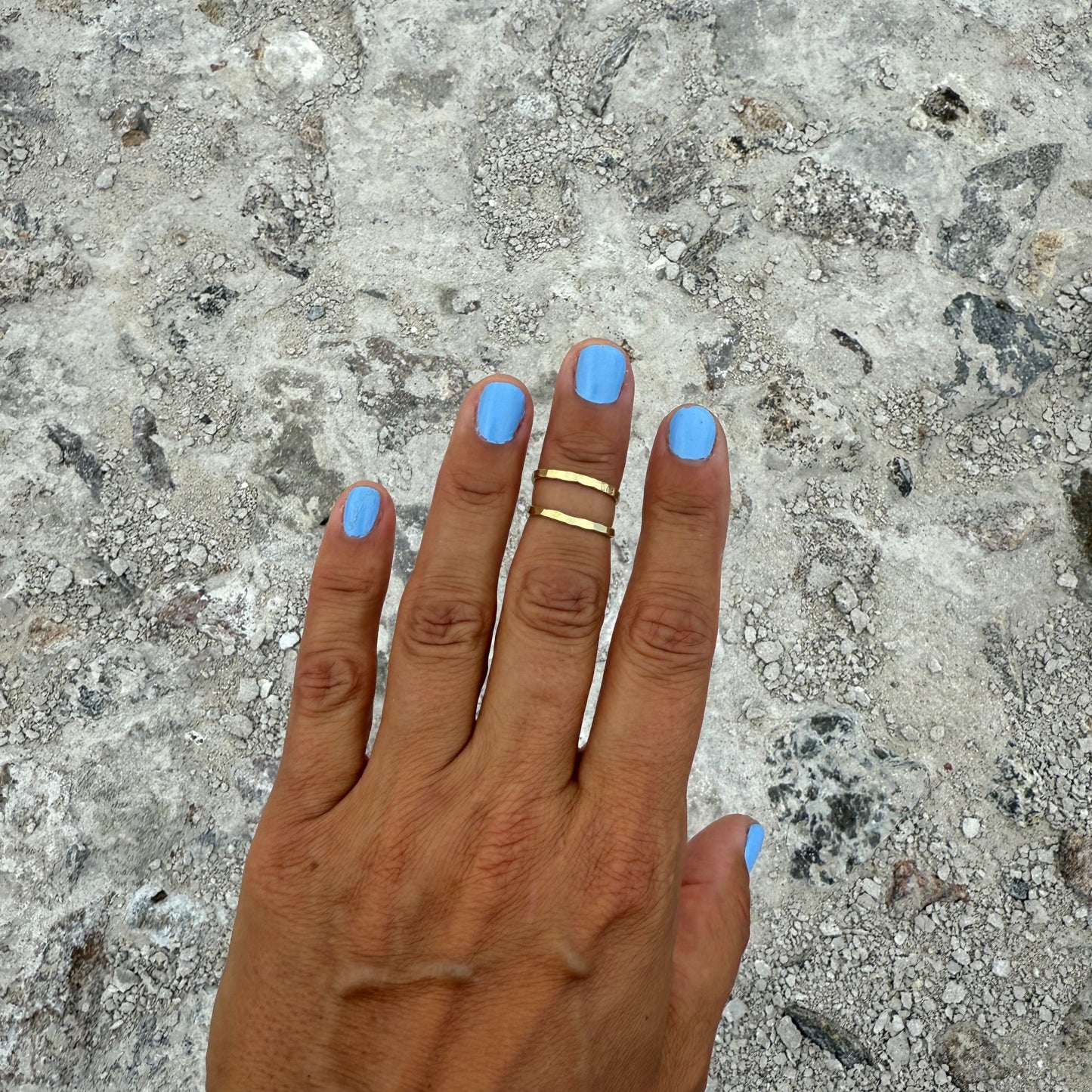 half-finger-ring in brass on tanneed hand with blue nail polish