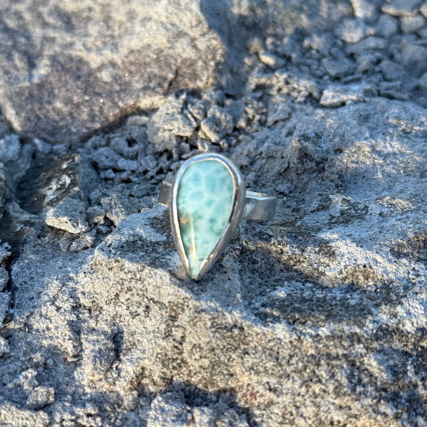 Ring with a turquoise stone on a textured stone surface