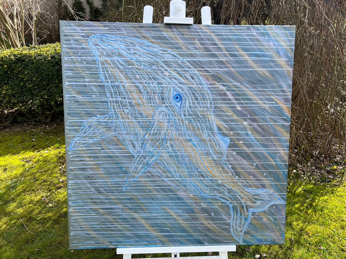 Abstract painting of a whale on an easel outdoors
