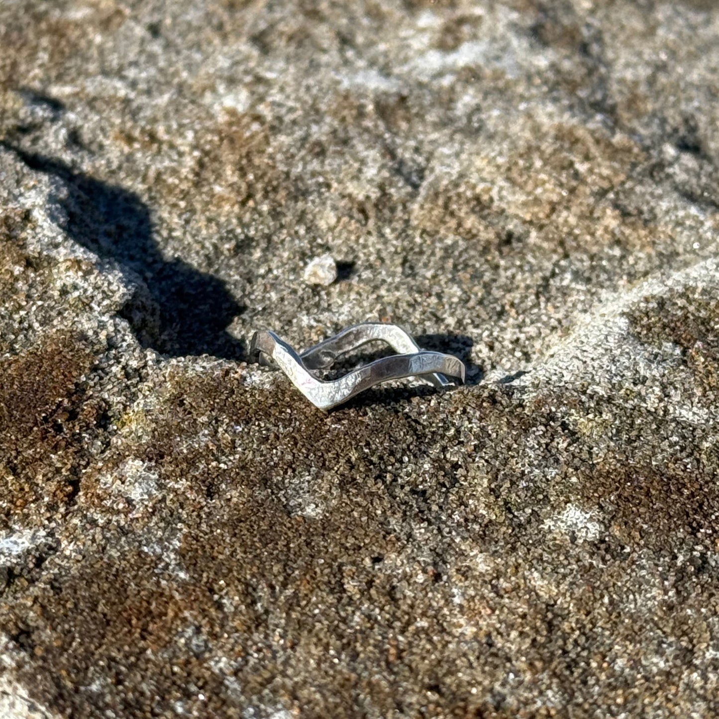 wave ring in silver 925 on a stone surfacee