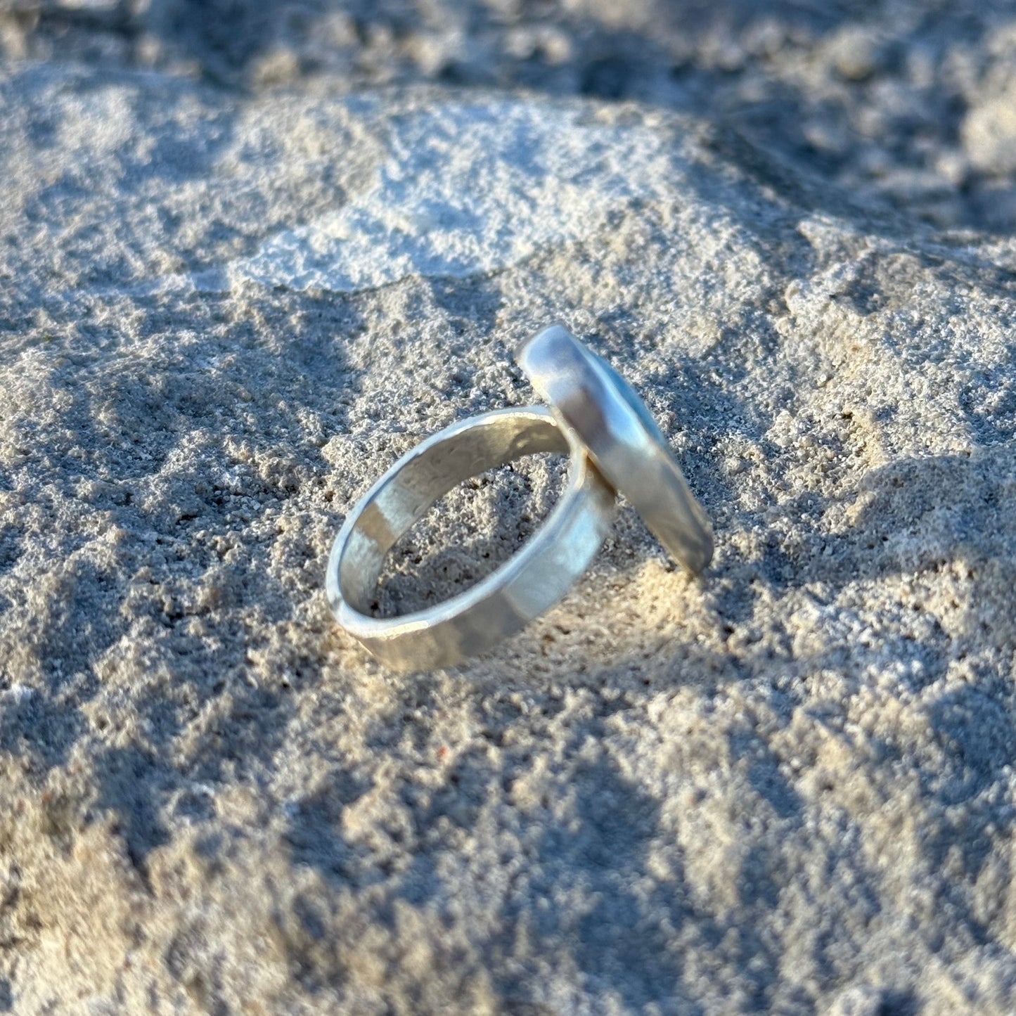 hammered unisex Silver ring on a textured stone surface