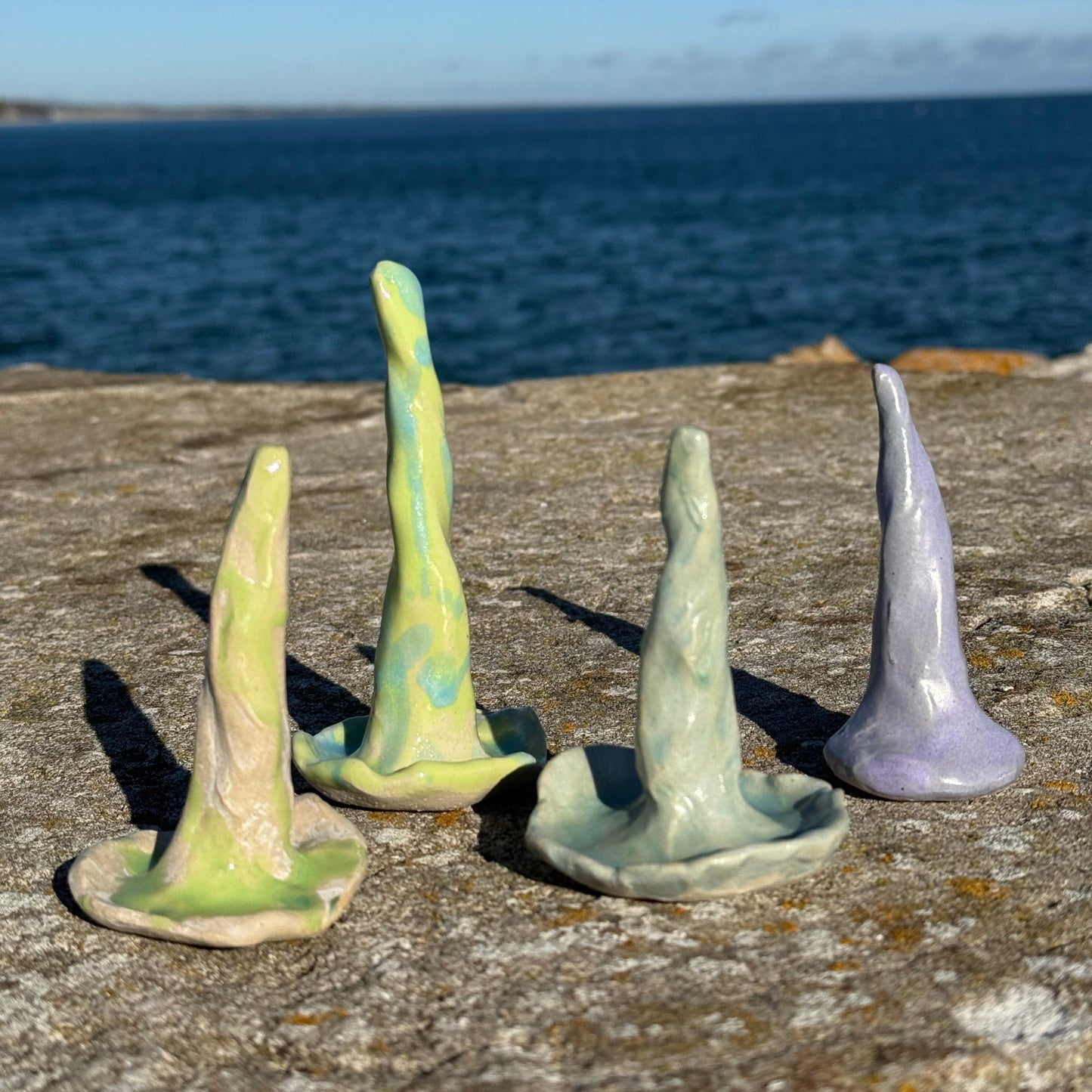 Set of ceramic ring cones in coral shapes on a textured surface with a blue gradient background.