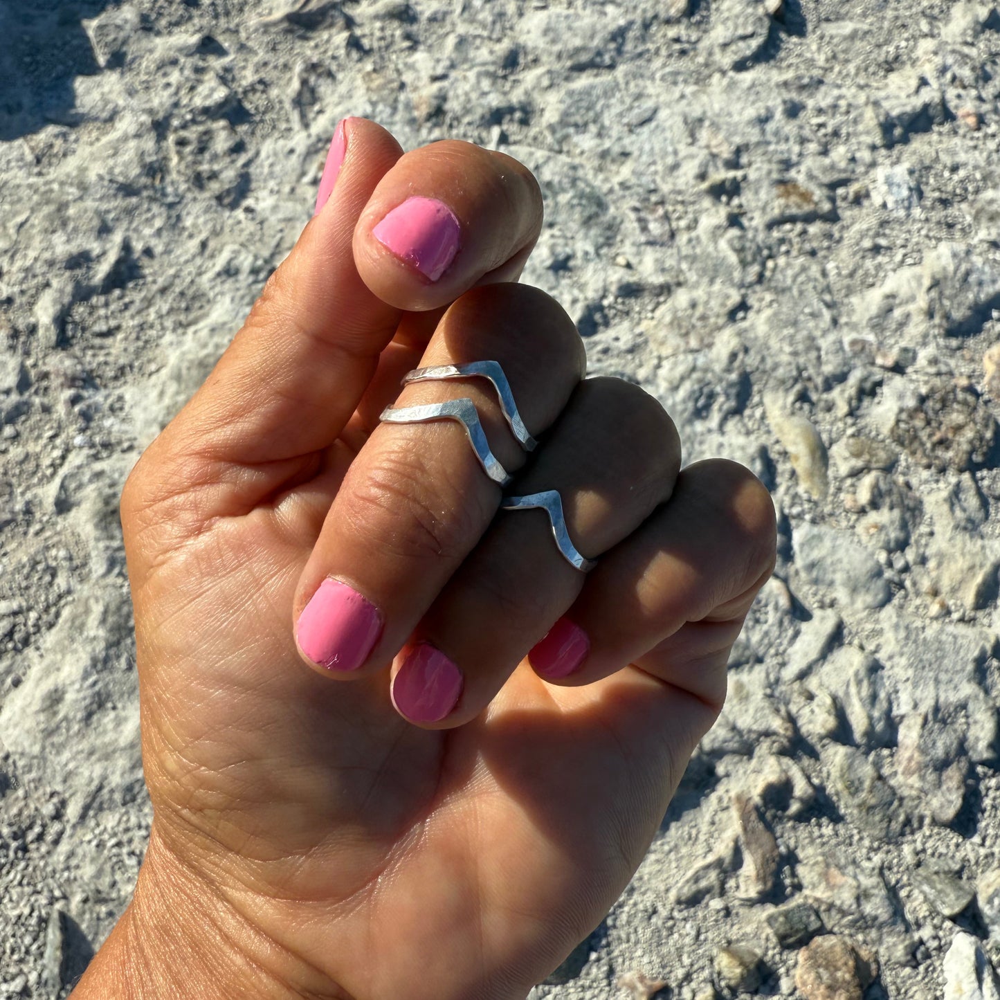 stacked upperfingerrings in silver 925 on a hand with pink nail polish