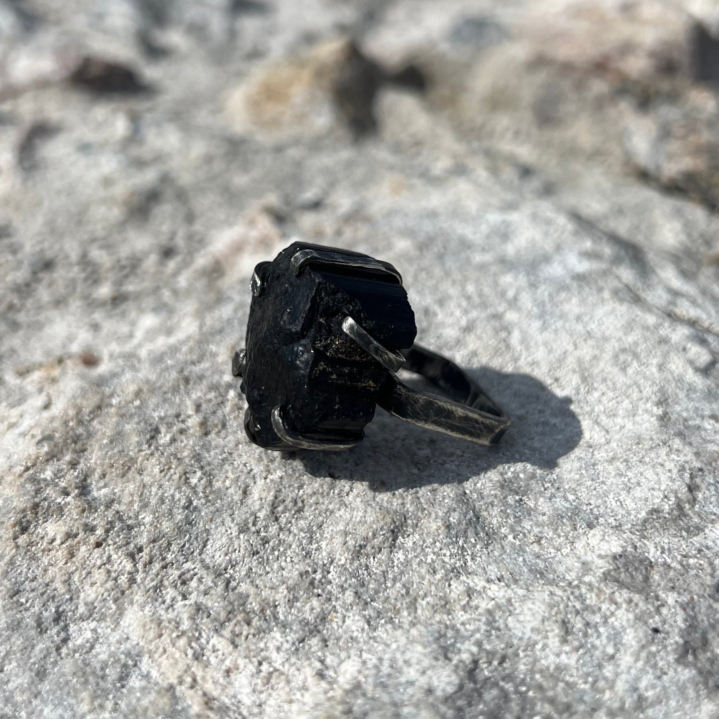 Black Tourmaline ring i oxidized silver 925 on a textured stone surface