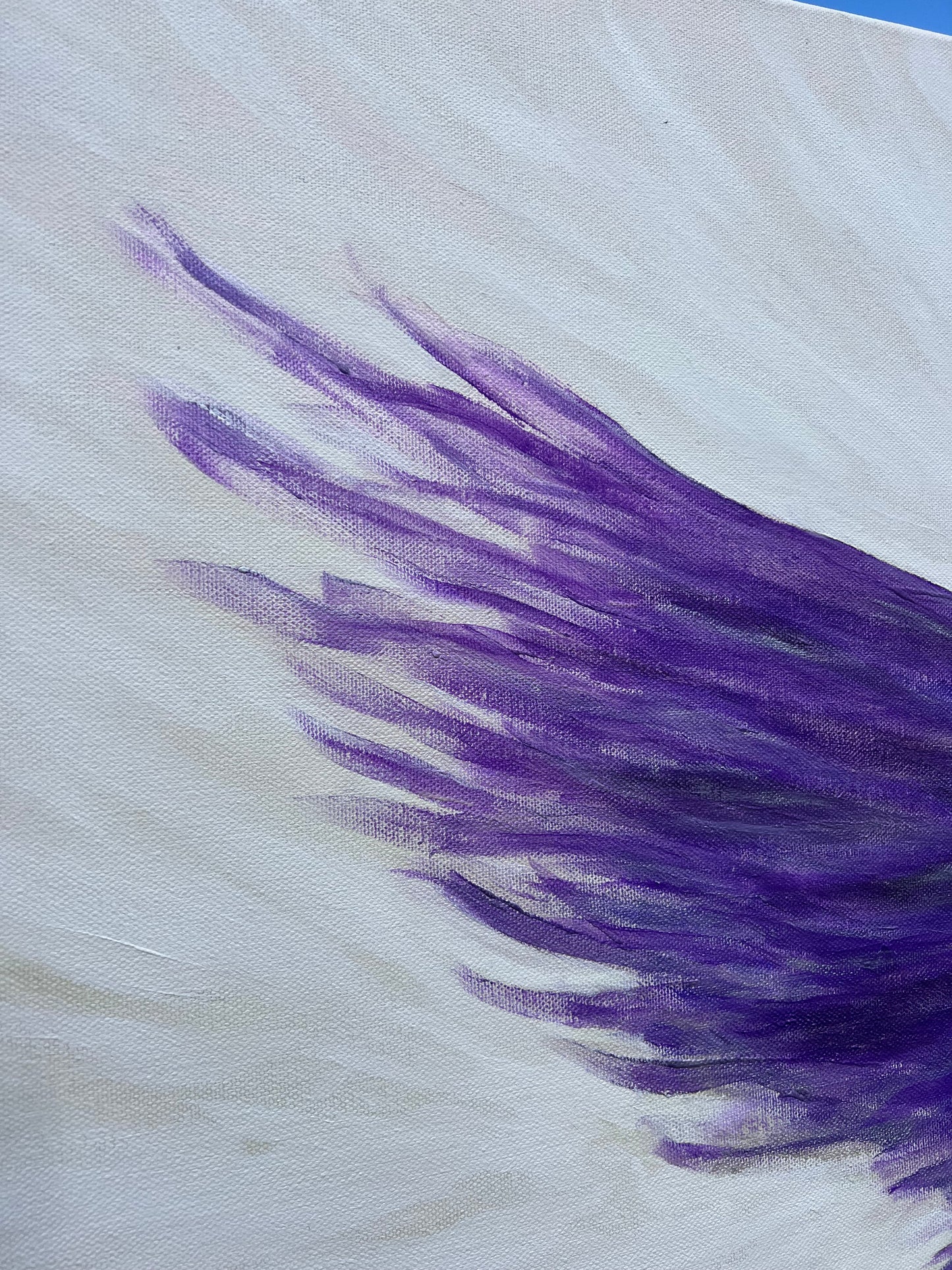 Close-up of a purple feather-like pattern on a white textured canvas background