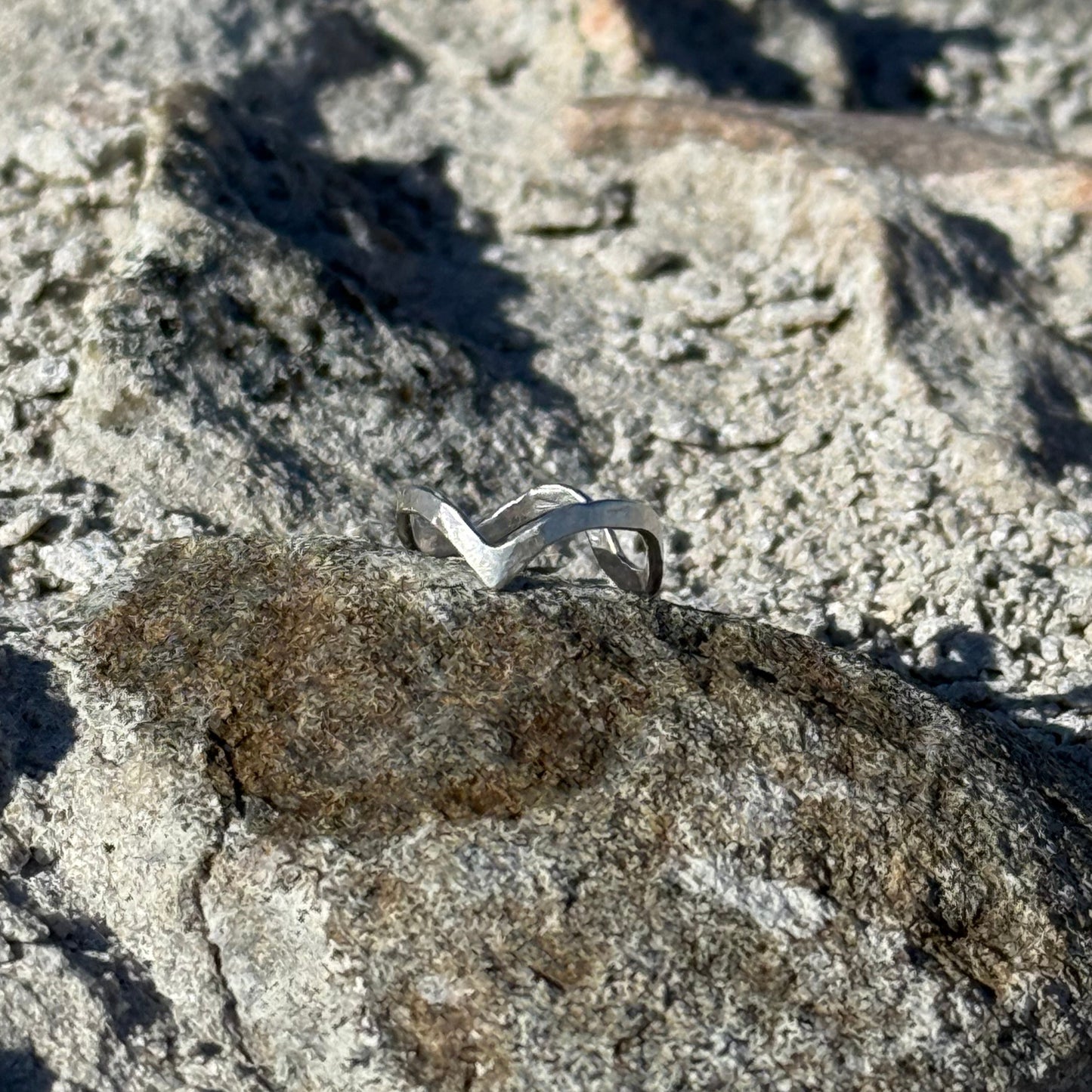 close up of a hammered wave-like sterling silver ring