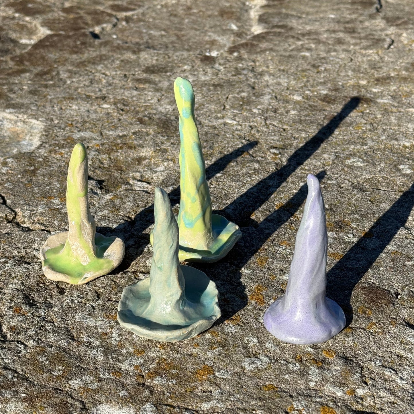 cluster of clay ring cones in bright colors on a textured stone surface