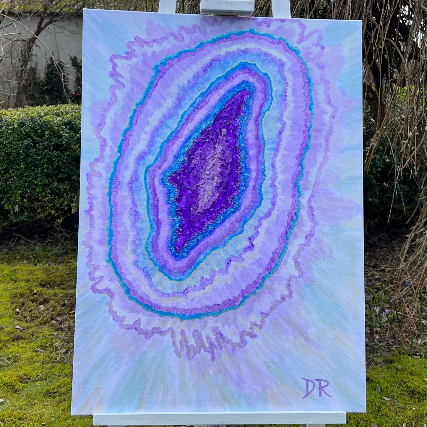 Artistic depiction of a purple and blue agate on a canvas outdoors.