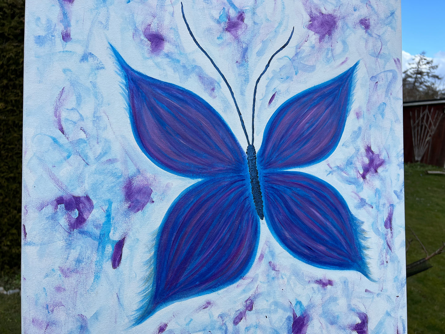 Painting of a blue butterfly on a canvas
