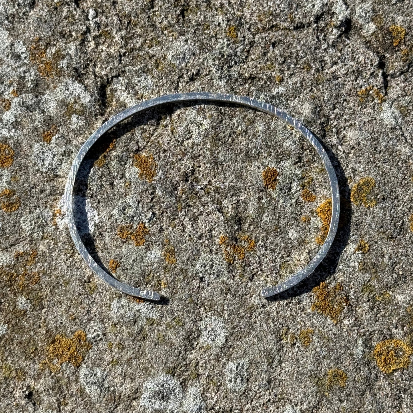 Sterlingsilver cuff on a textured stone surface