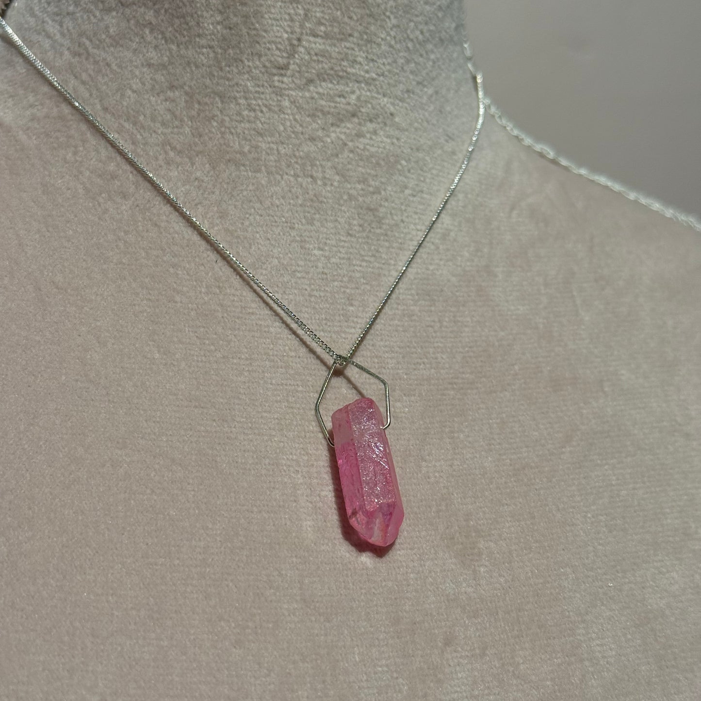 Pink titanium quartz crystal necklace on a soft pink mannequin