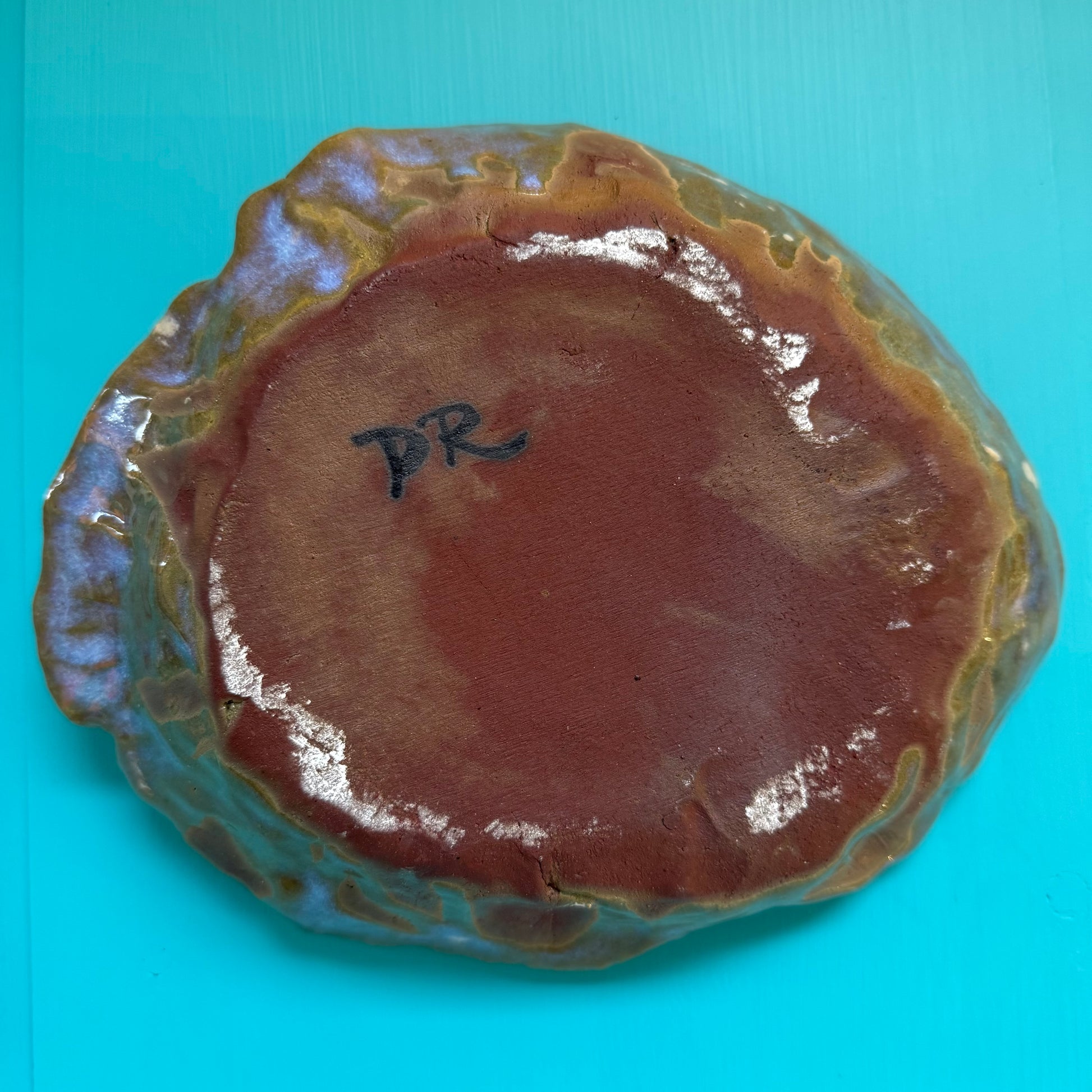Ceramic bowl with a brown glaze on a blue background