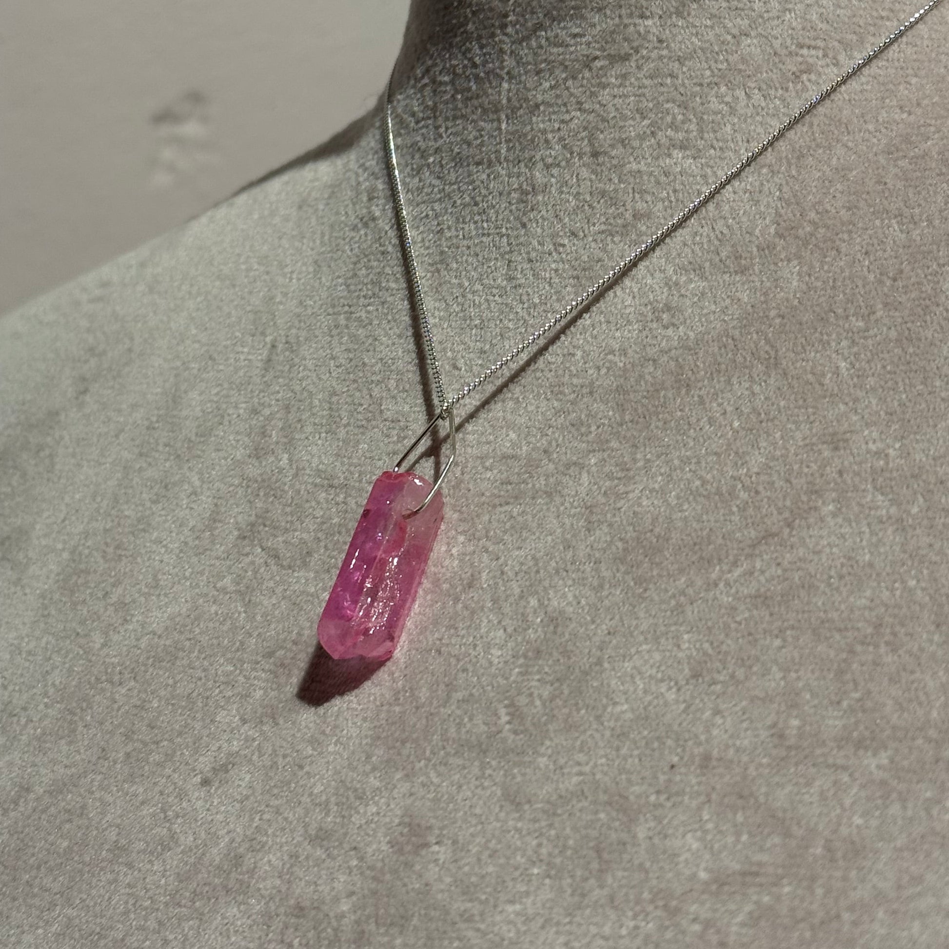 Pink crystal on a mannequin with a neutral background