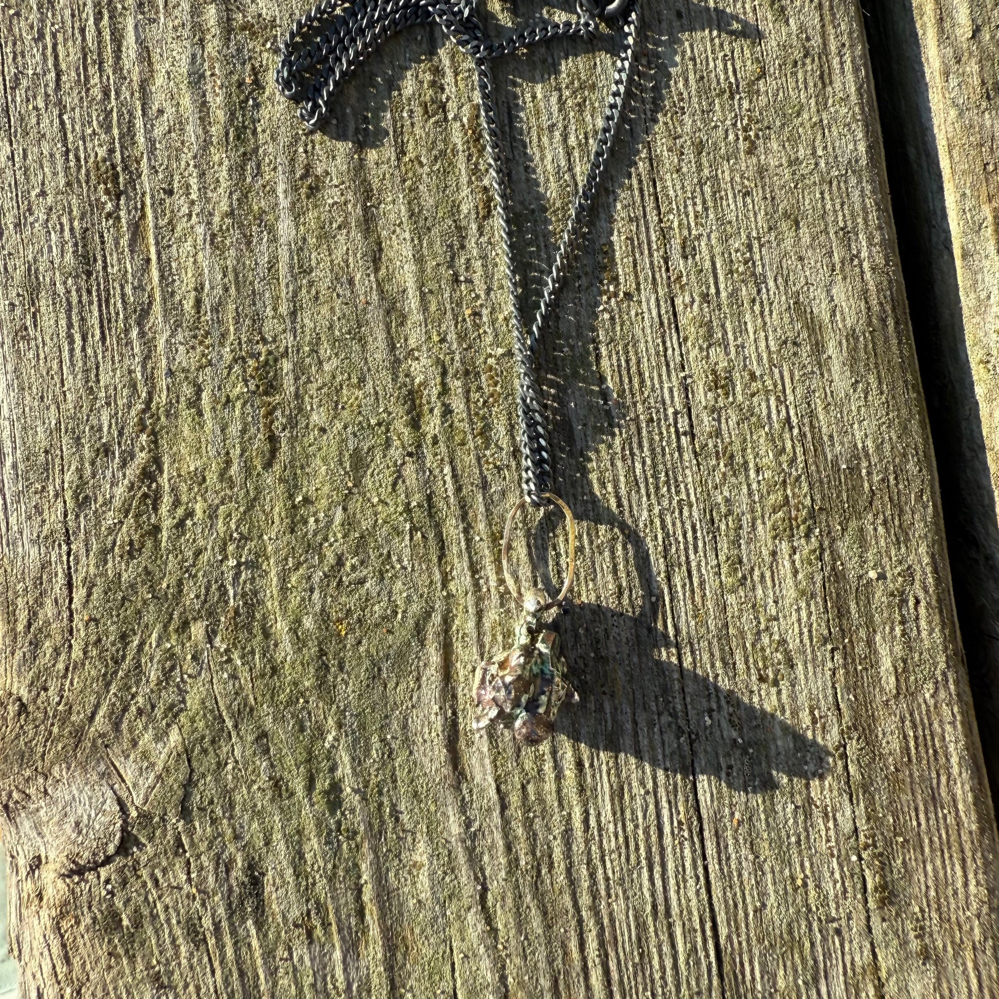 Oxidized silver Necklace with a pendant on a wooden surface