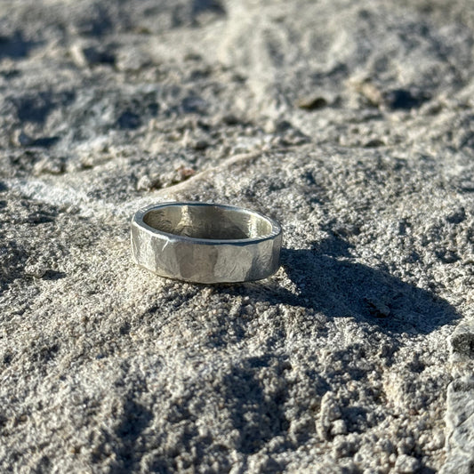 chunky hammered Silver ring on a textured stone surface