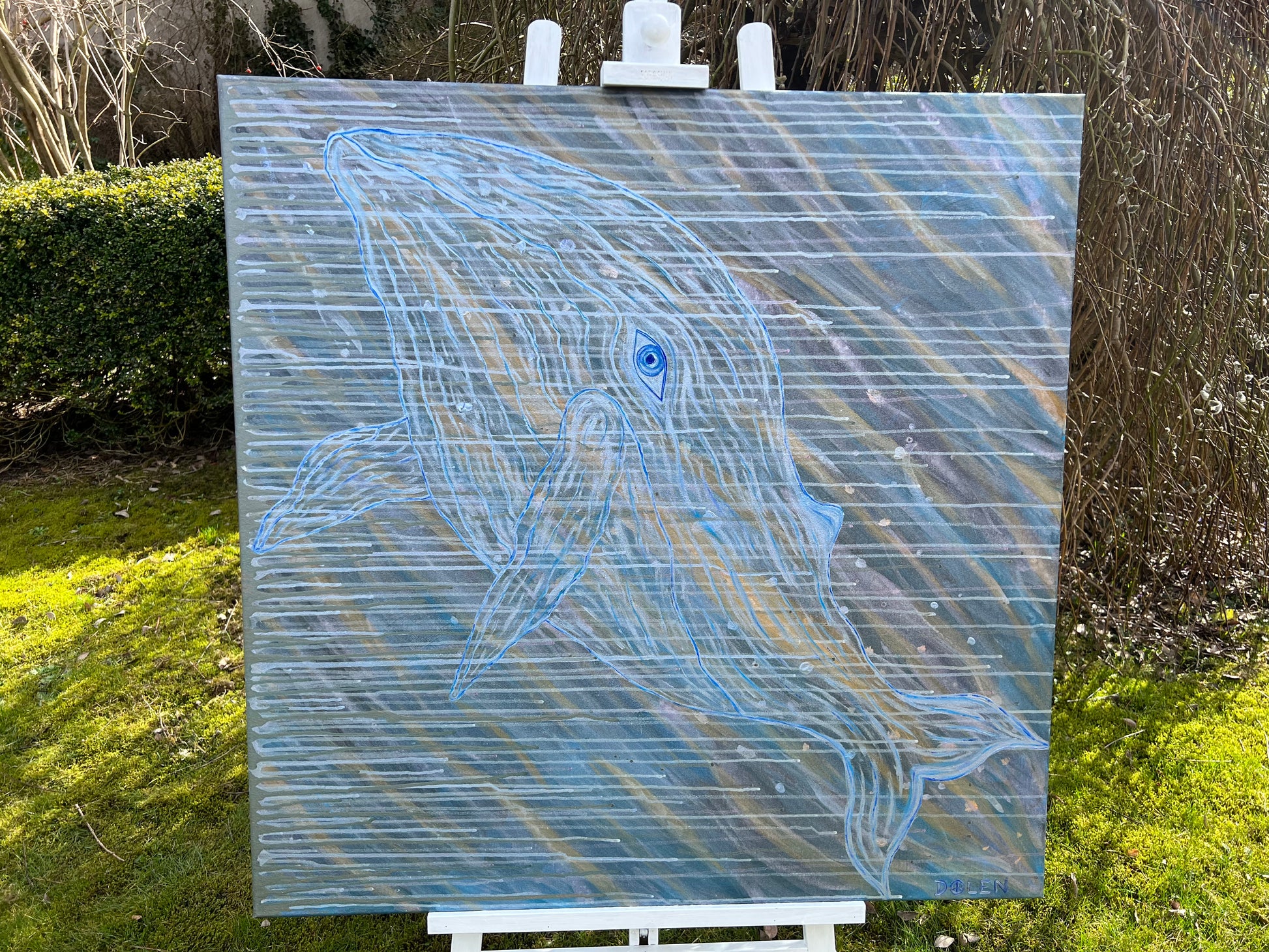 Abstract painting of a whale  on an easel outdoors