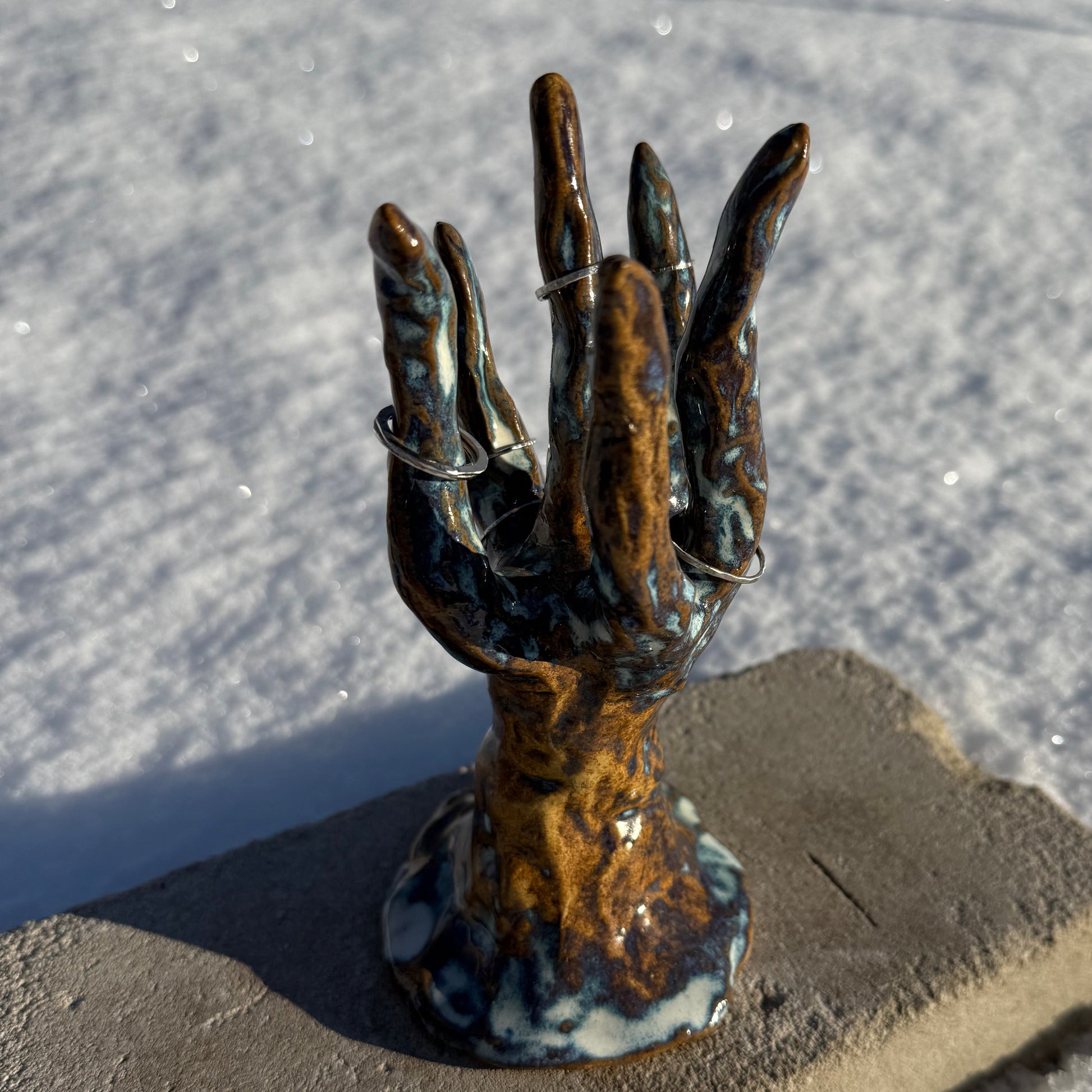 ceramic jewelry holder in thee shape of a coral cluster on concrete and snow