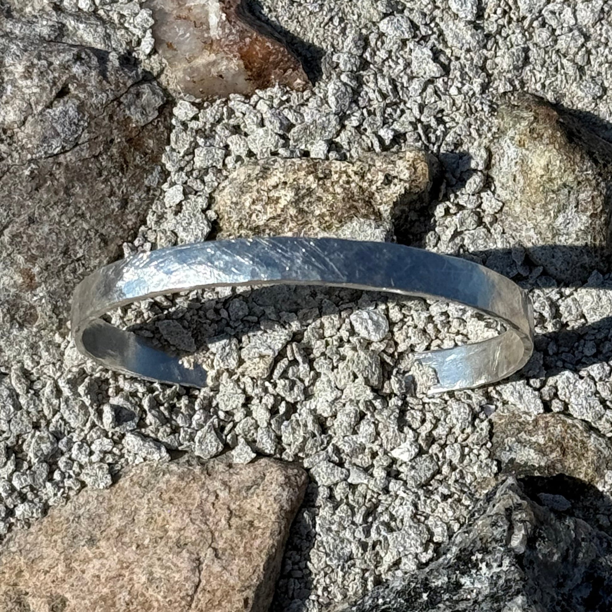 Silver bracelet on a textured stone surface