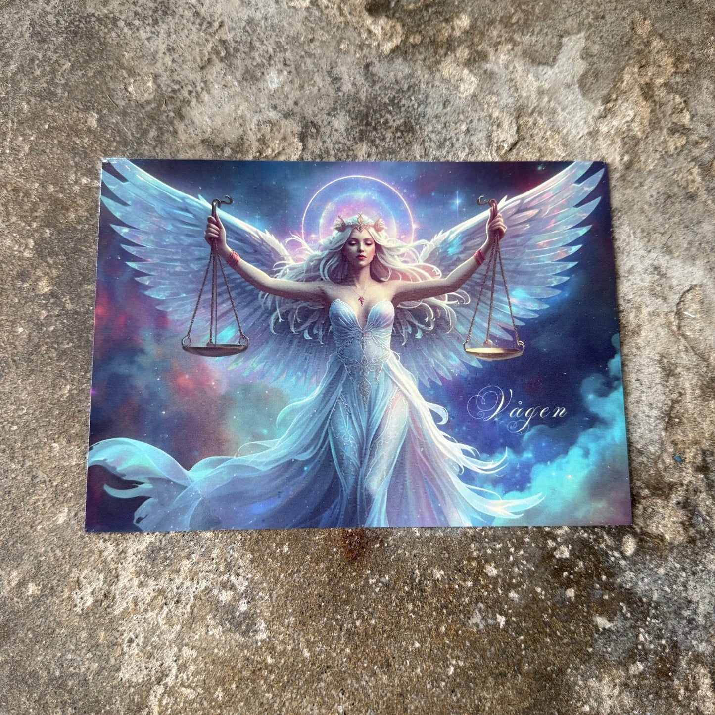 Card with an angelic figure holding scales on a textured surface for the star sign libra