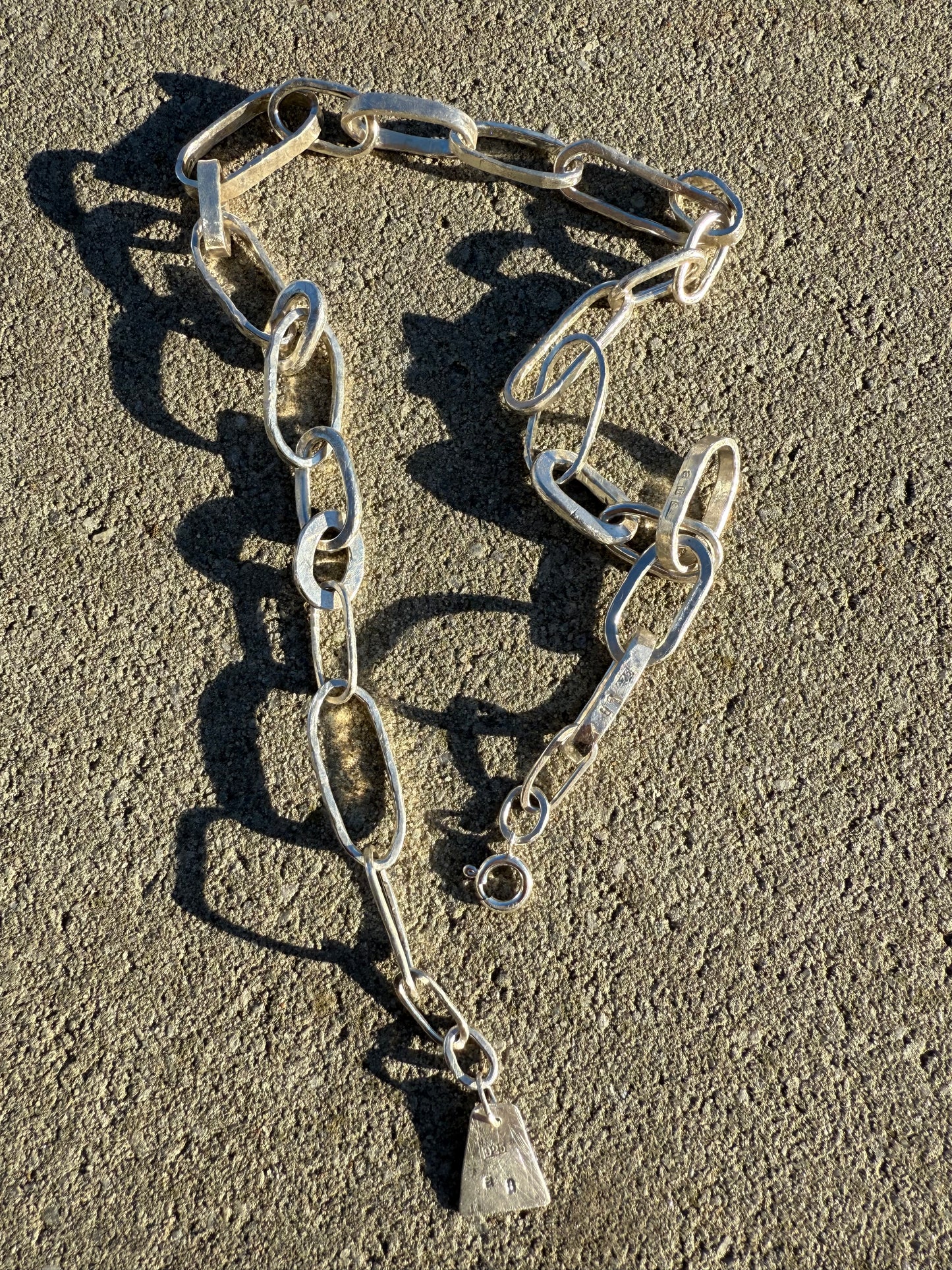 Silver chain necklacee on a textured surface