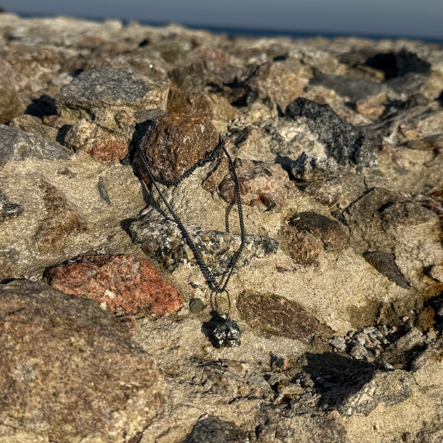 Necklace with a pendant on a rocky surface