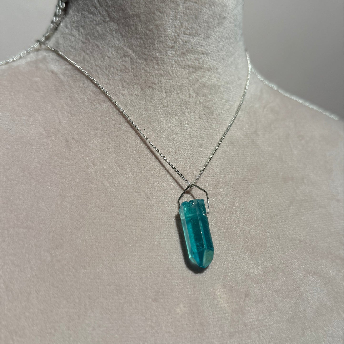 Teal crystal on a gray surface