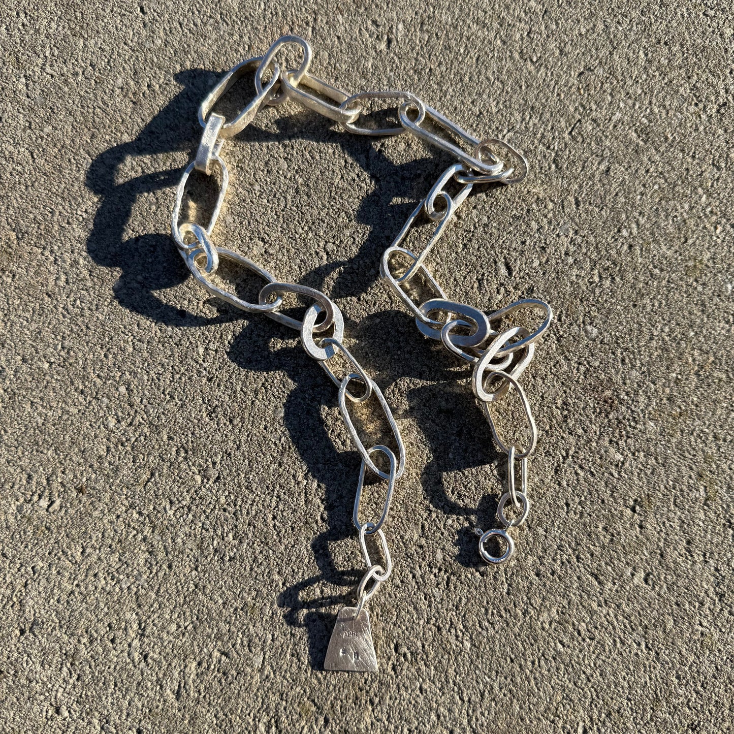 Handmade chunky chain necklace in silver  925 on a textured surface