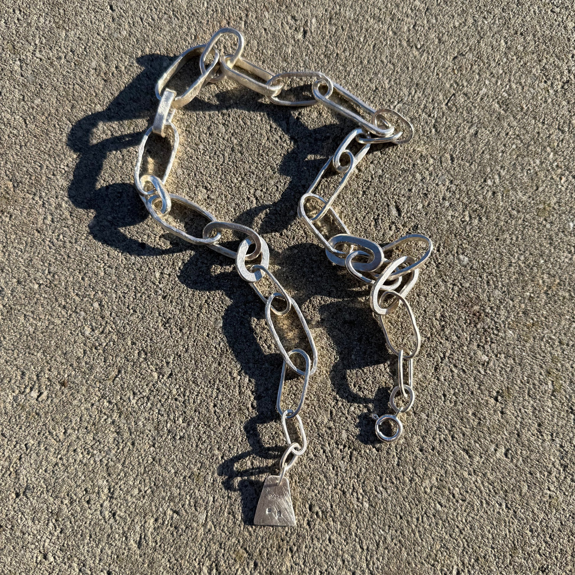 Handmade chunky chain necklace in silver  925 on a textured surface