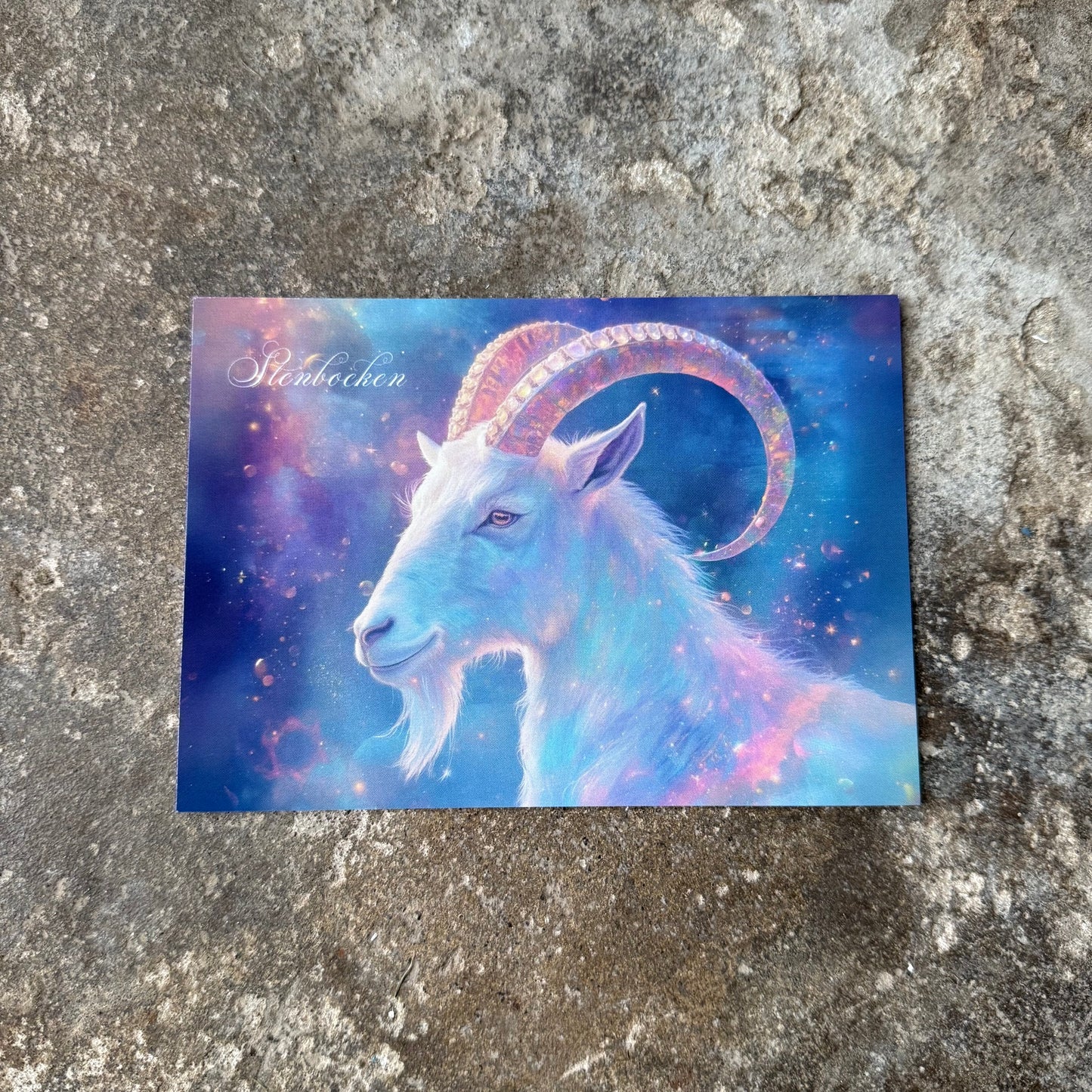 Card with a colorful goat illustration on a textured surface for the star sign of capricorn