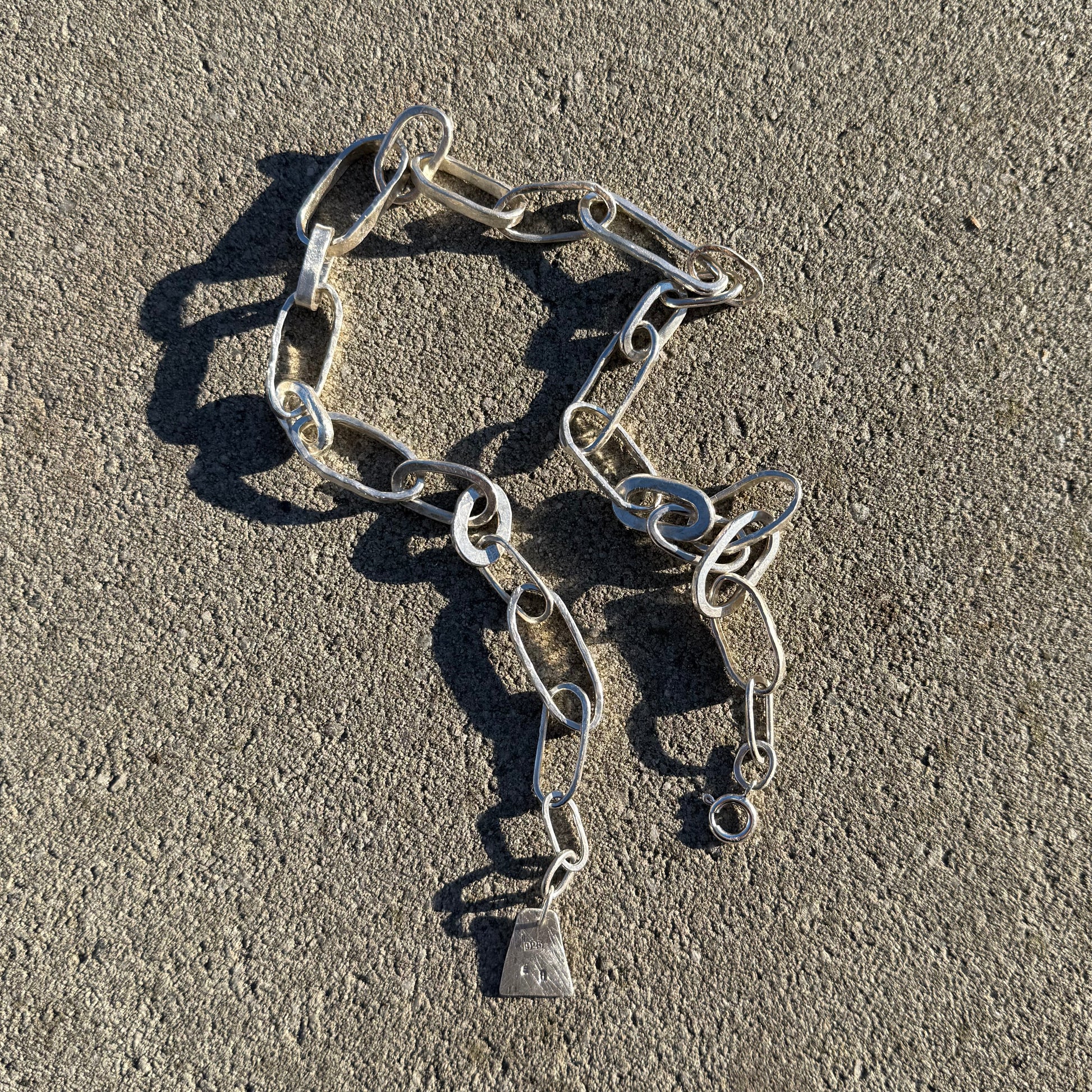 silver chain necklace on a concrete surface