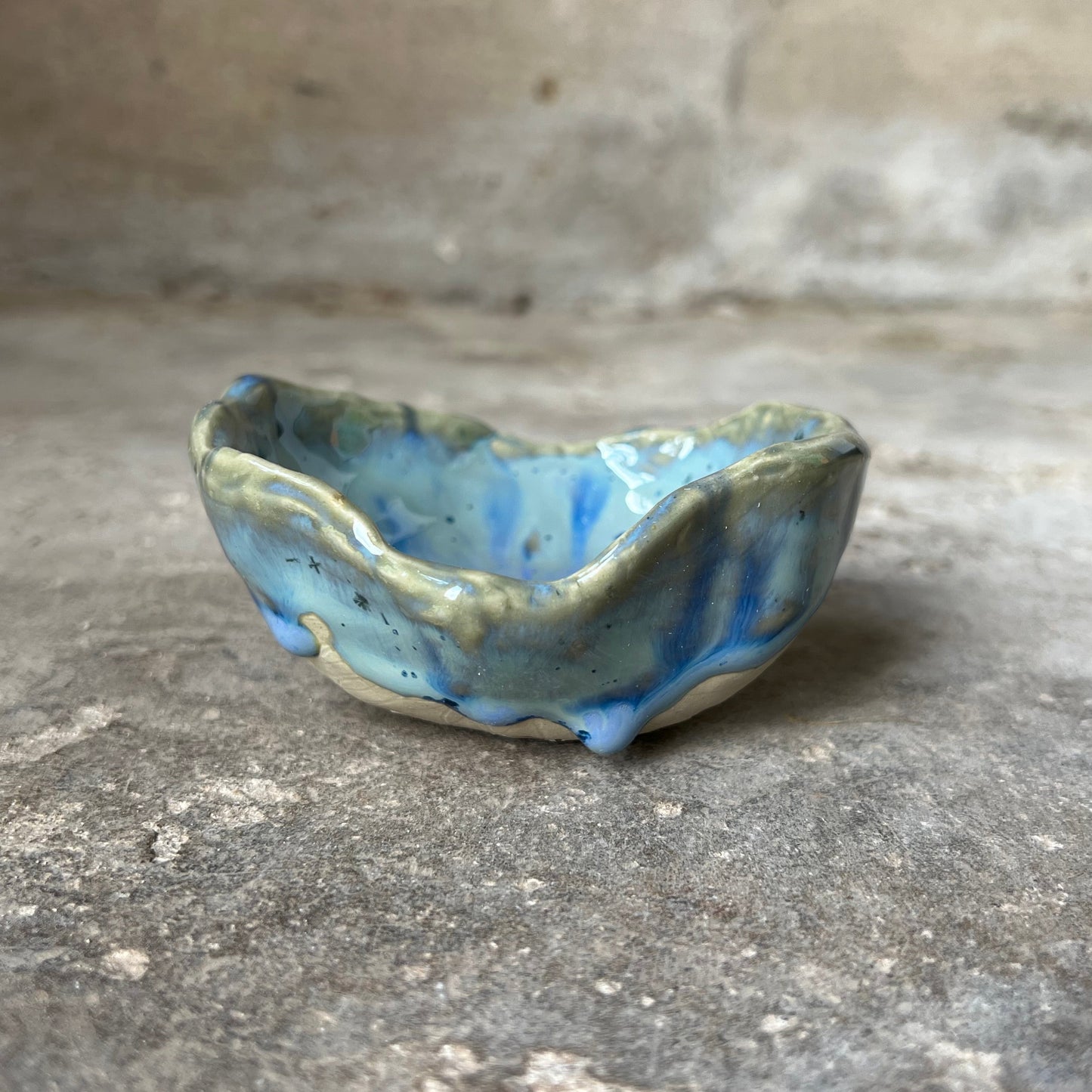 Small seashell soap dish in ceramic on a concrete surface