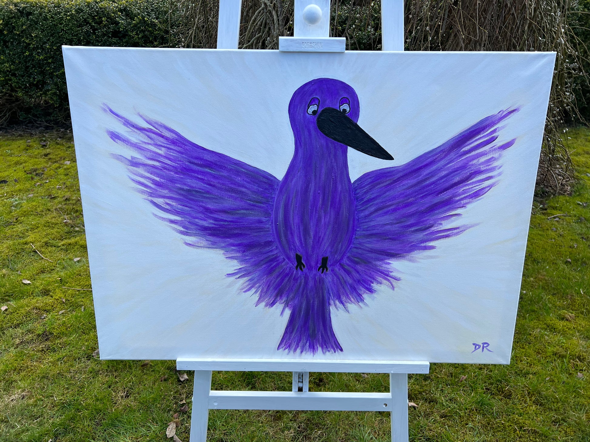 Painting of a purple bird on a white canvas outdoors.