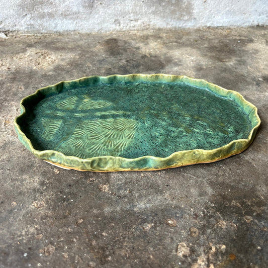 Green ceramic dish on a concrete surface