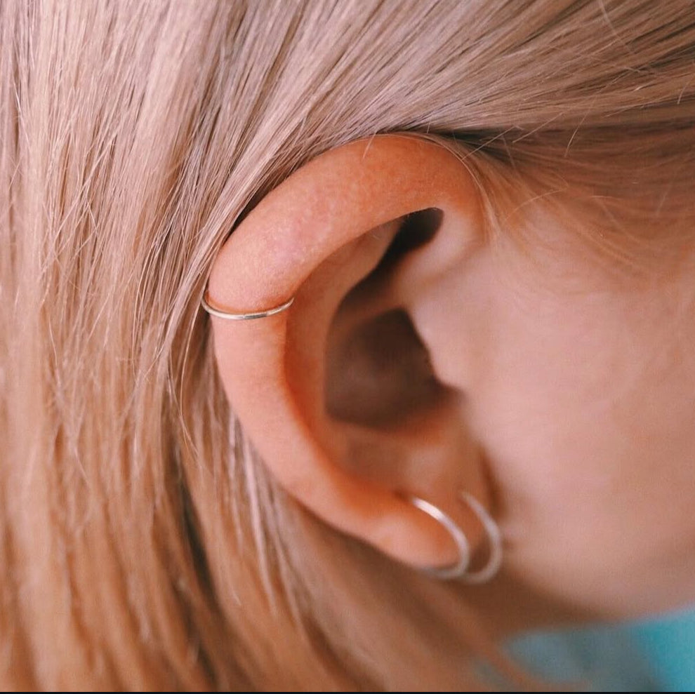 Close-up of an ear with small hoop earrings